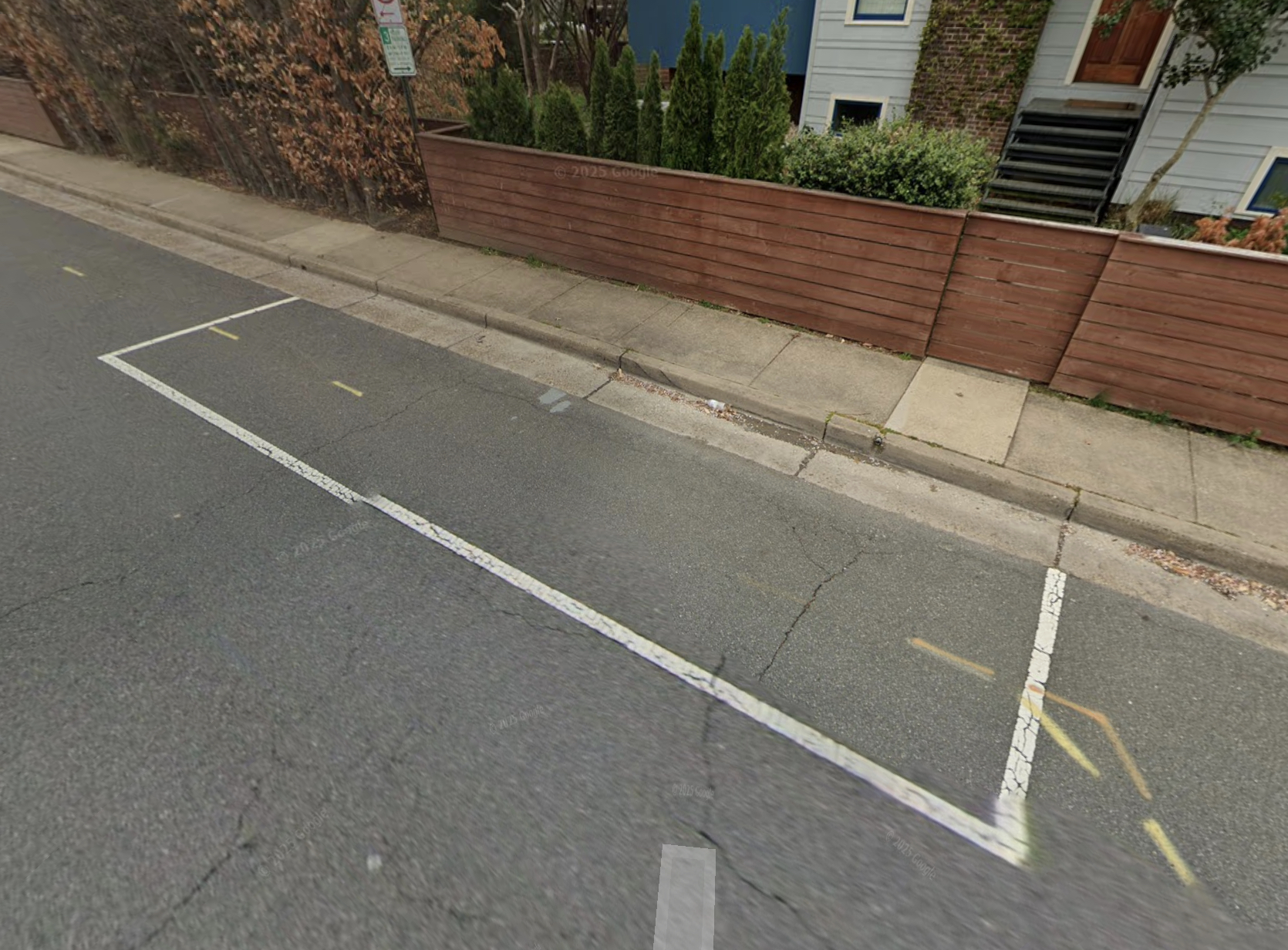 An empty on-street parking space on Braddock Road, Alexandria, VA — painted white lines marking where a car once could have been